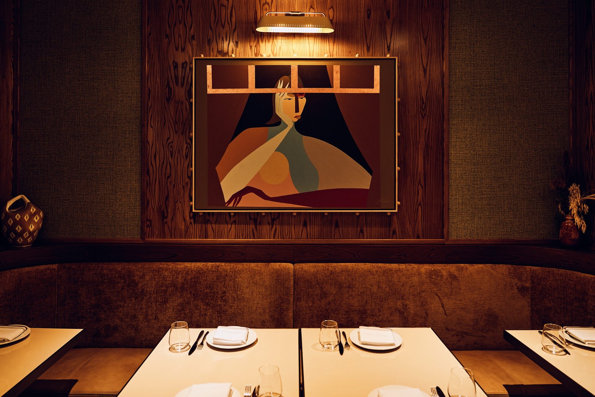 Eloise dining room — banquette seating, white tablecloths, portrait of Eloise on the back wall