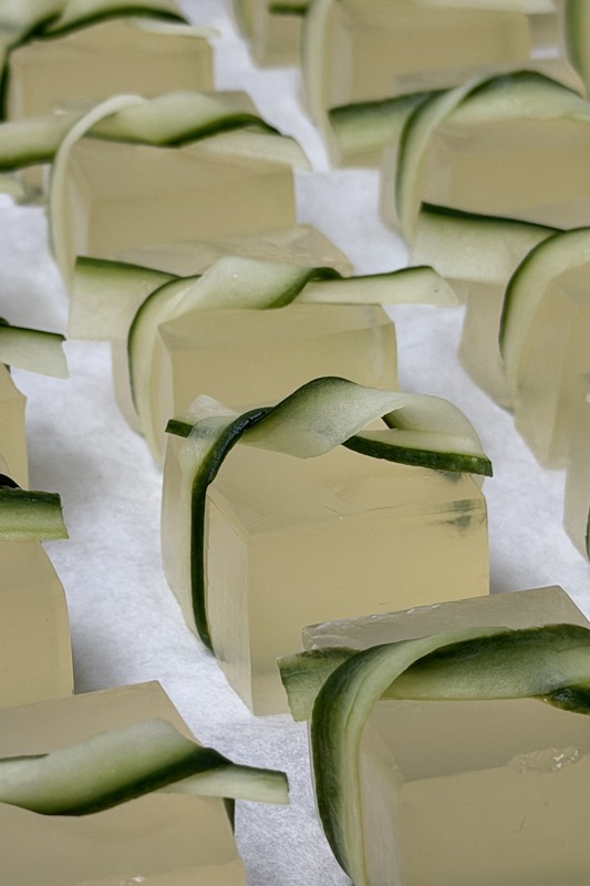 Cucumber-ribbon jello cubes in neat rows