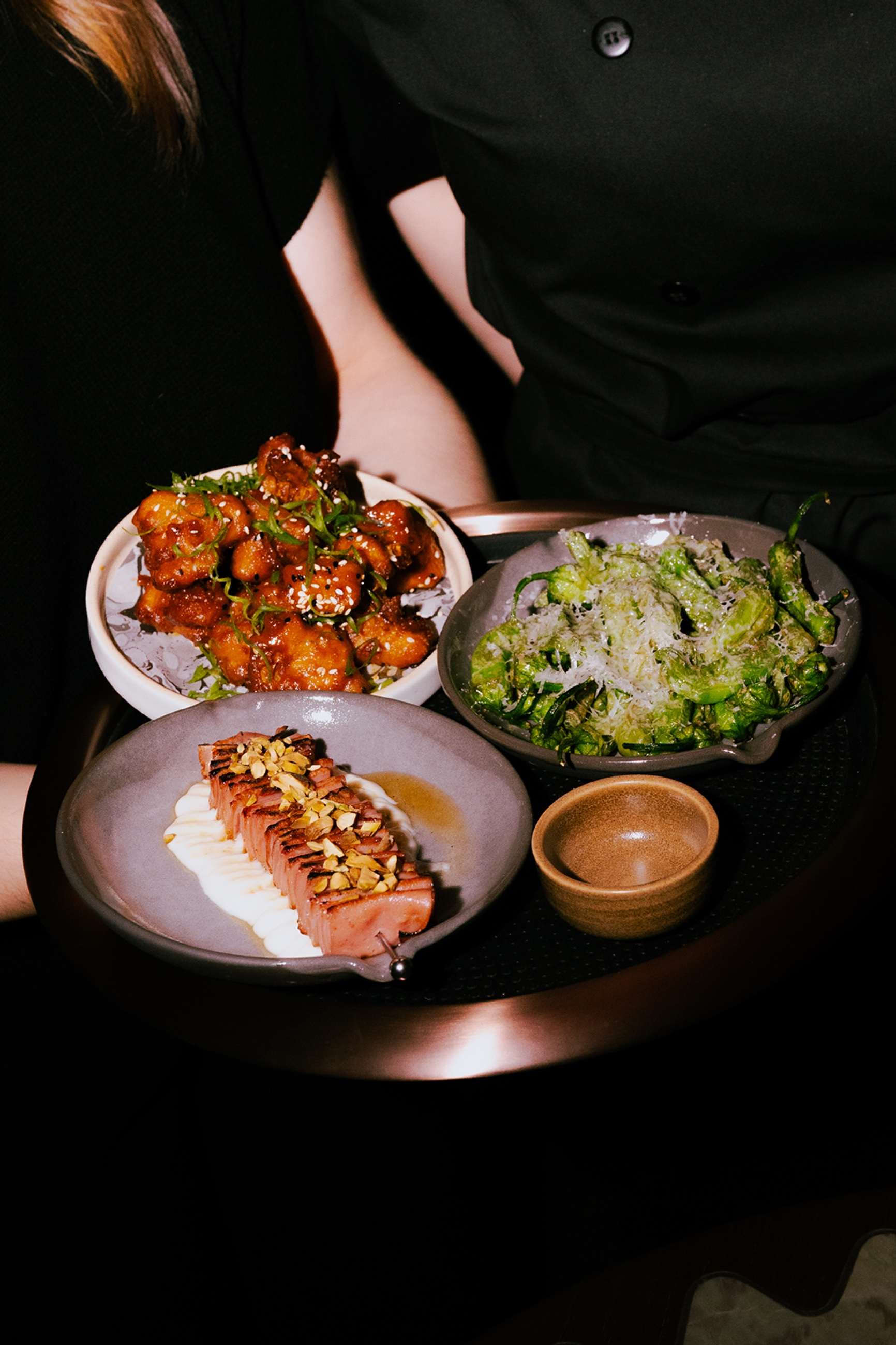 Server carrying plates through the amber-lit room